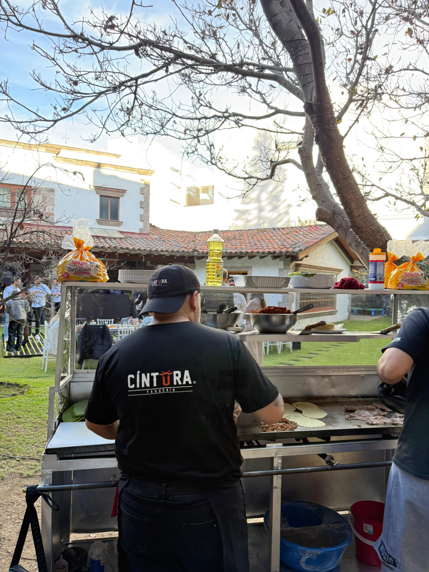 Taquero de Cíntora preparando tacos en un evento