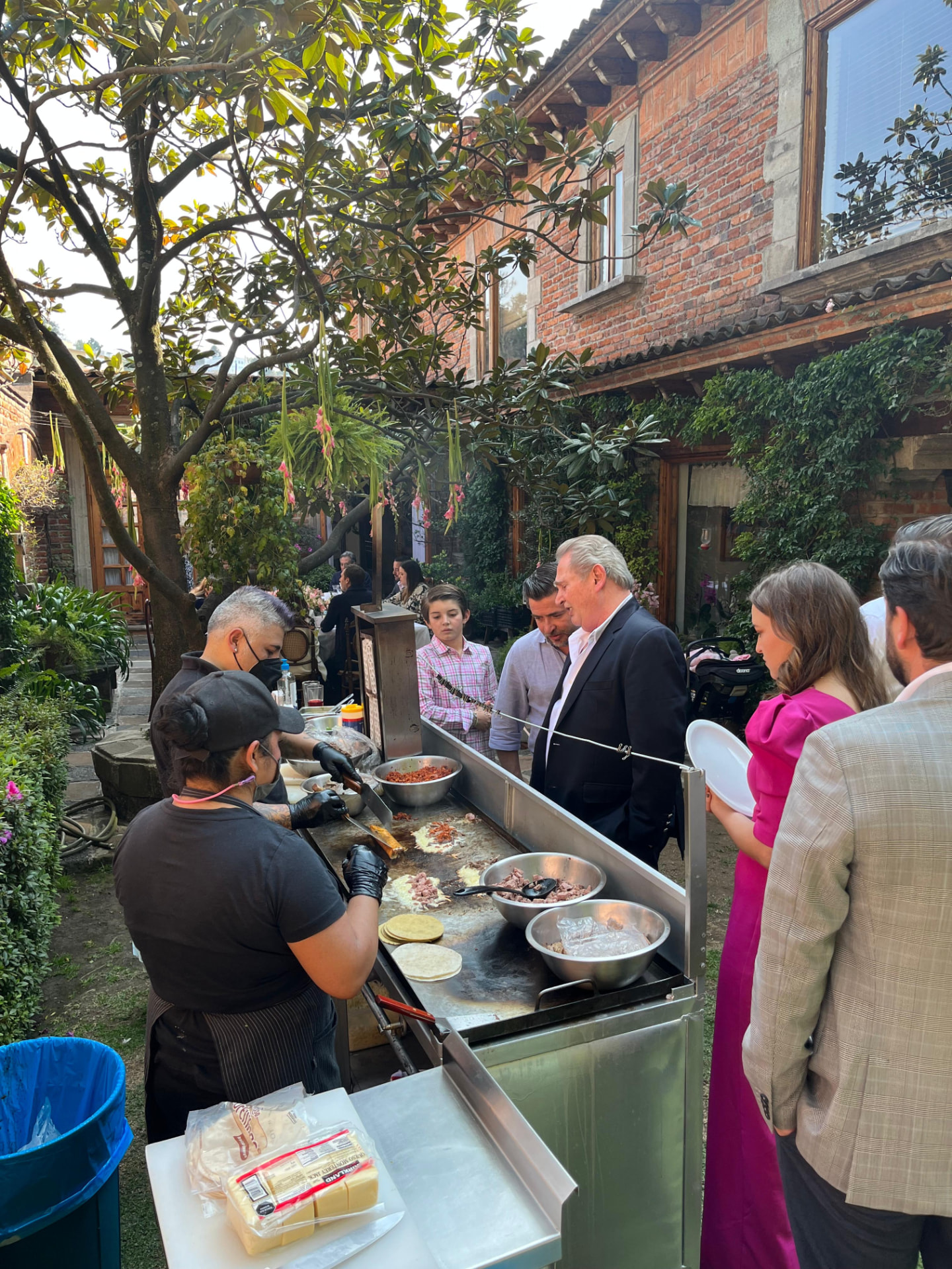 Taqueros preparando tacos en un evento al aire libre